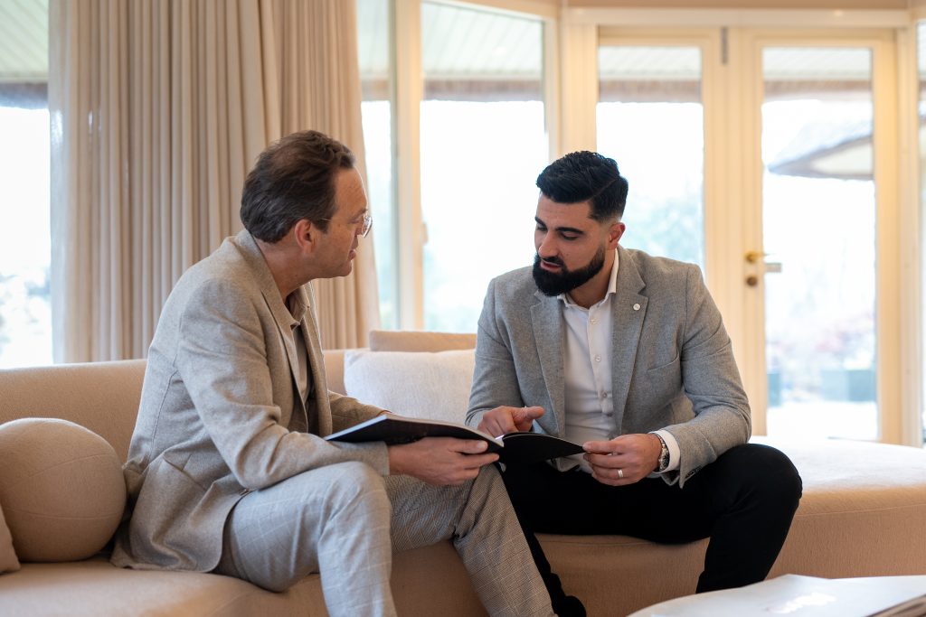 Two business professionals discussing documents during in-home real estate consultation